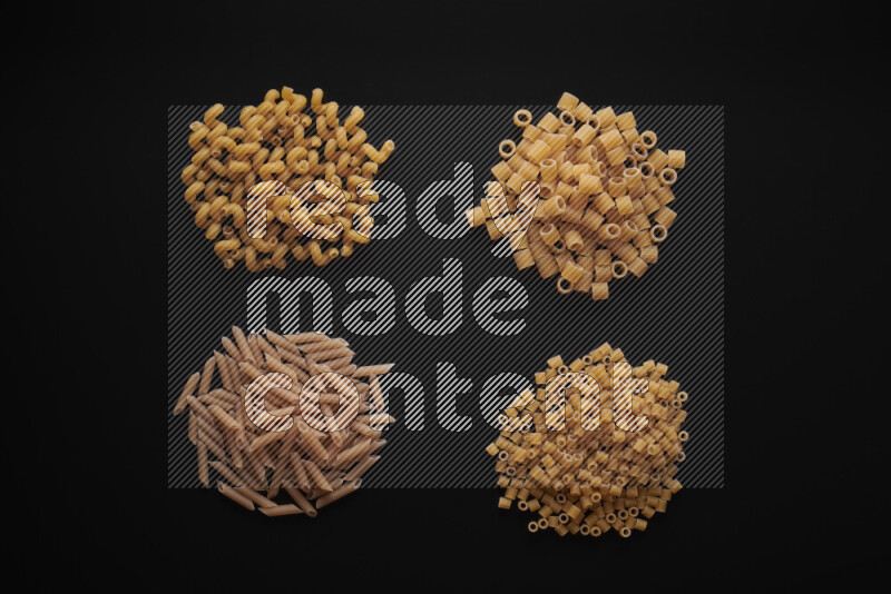Different pasta types in bunches on black background
