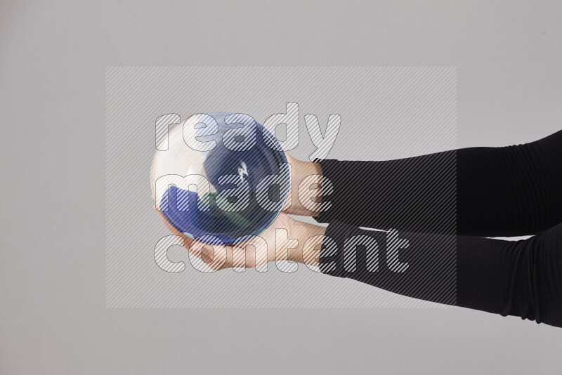 امرأة ترتدي عباءة سوداء تحمل أدوات فخارية مختلفة في أوضاع متعددة