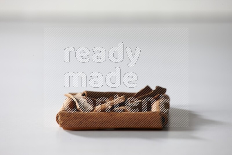 A single square of cinnamon sticks full of cinnamon on white flooring