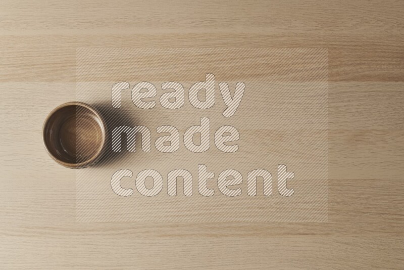 وعاء فخاري بيج على خلفية خشبية فاتحة