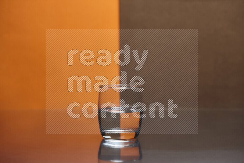 The image features a clear glassware filled with water, set against orange and brown background