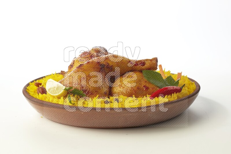 yellow basmati Rice with kabsa chicken pieces on a pottery plate direct on white background