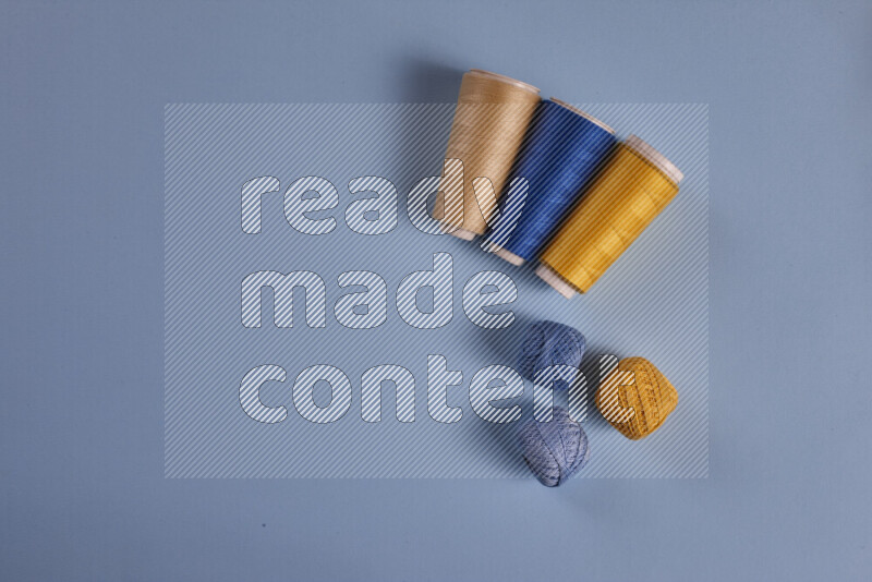 A yellow and blue collection of sewing and tailoring tools arranged on a blue background
