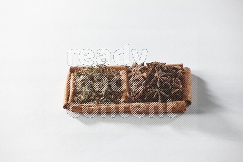 2 squares of cinnamon sticks full of star anise and dried basil on white flooring