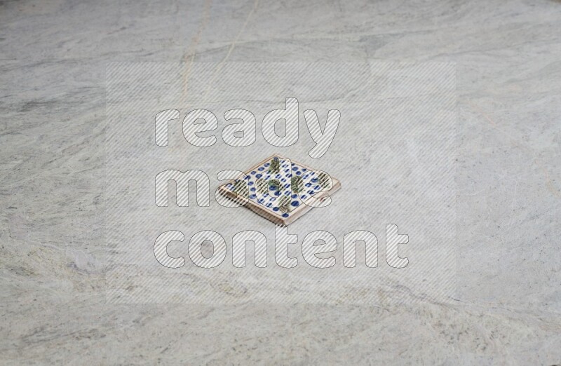 Top view shot of a pottery coaster\ tile on beige marble flooring