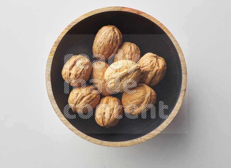 Top-view shot of walnut in a container on white background