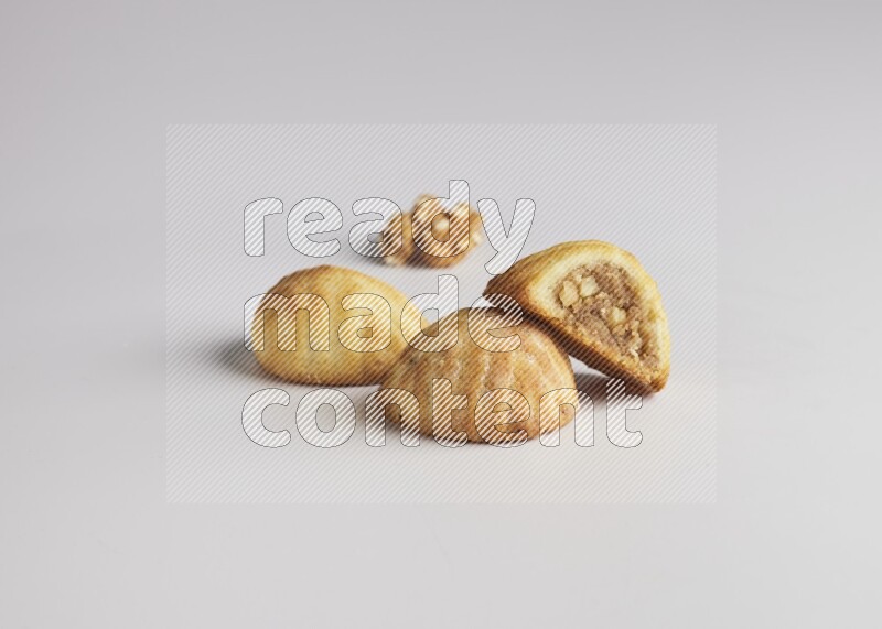 Three Pieces of Maamoul filled with walnut paste  one of them is cut direct on white background