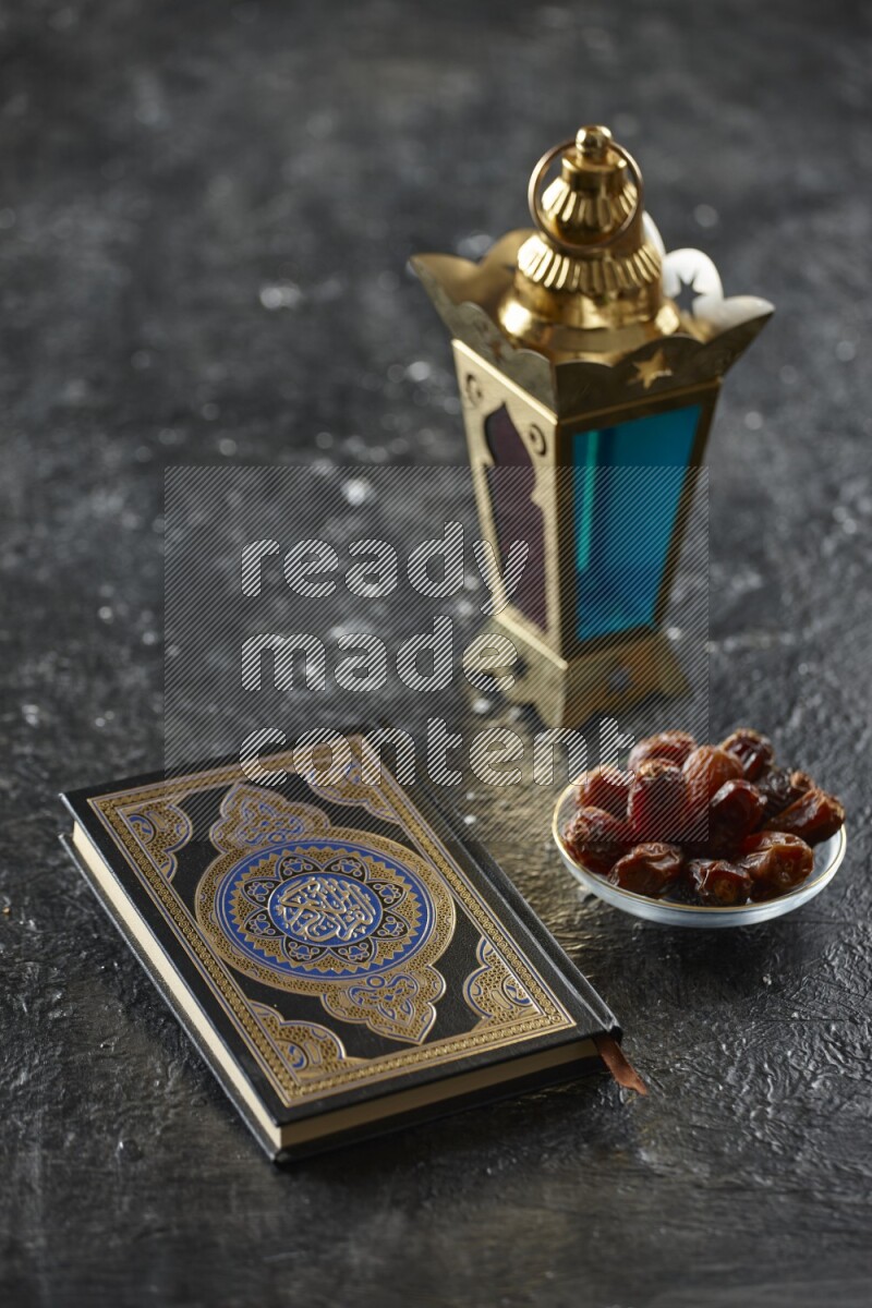 A golden lantern with different drinks, dates, nuts, prayer beads and quran on textured black background