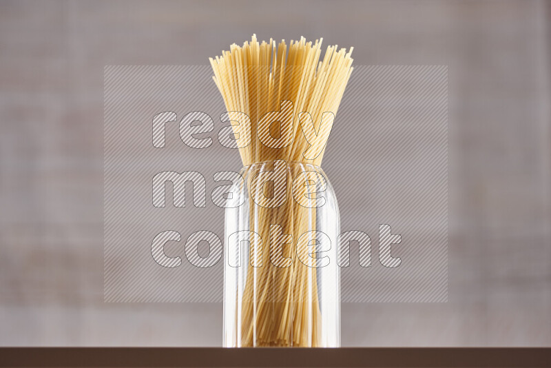 Raw pasta in glass jars on beige background
