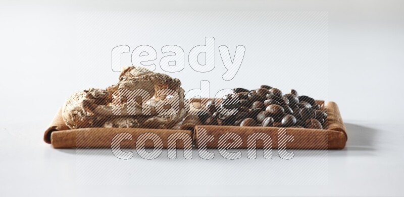 2 squares of cinnamon sticks full of coffee beans and dried ginger on white flooring