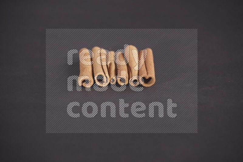 Cinnamon sticks stacked on black flooring