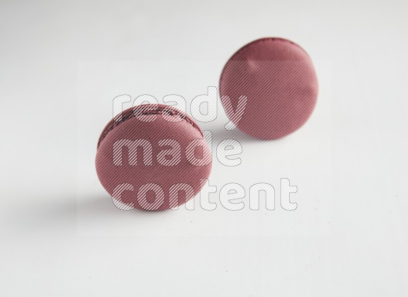 45º Shot of two Red Cherry macarons on white background