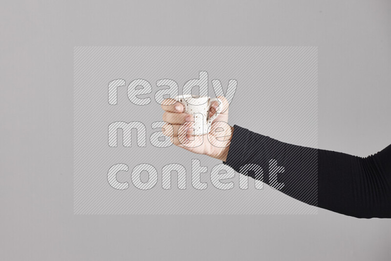 A woman in black abaya holding different pottery essentials in different positions