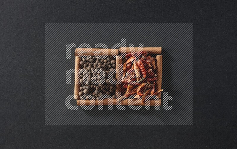 2 squares of cinnamon sticks full of chilis and allspice on black flooring