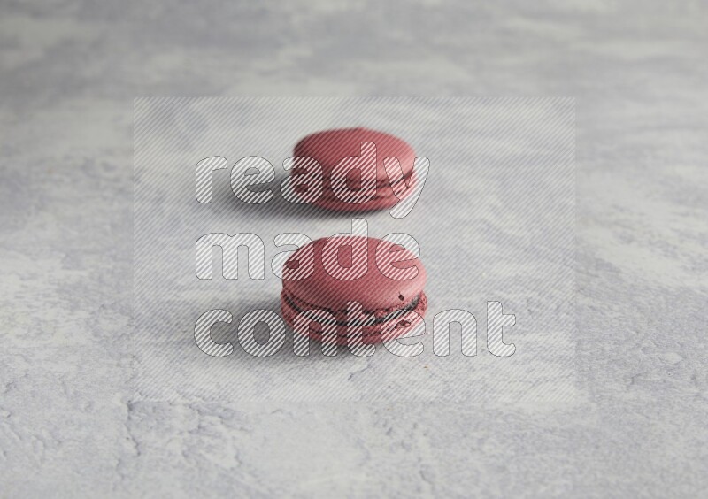 45º Shot of two Red Cherry macarons  on white  marble background