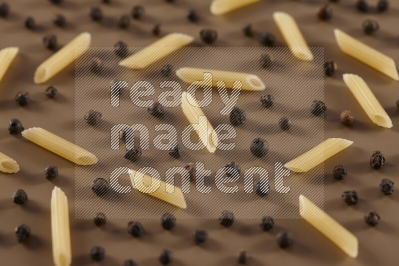 معكرونة مع مكونات متنوعة من الطماطم والثوم والبصل والفلفل الأحمر والفلفل الأسود والفلفل الأبيض وأوراق الغار وإكليل الجبل والهيل على خلفية بيج