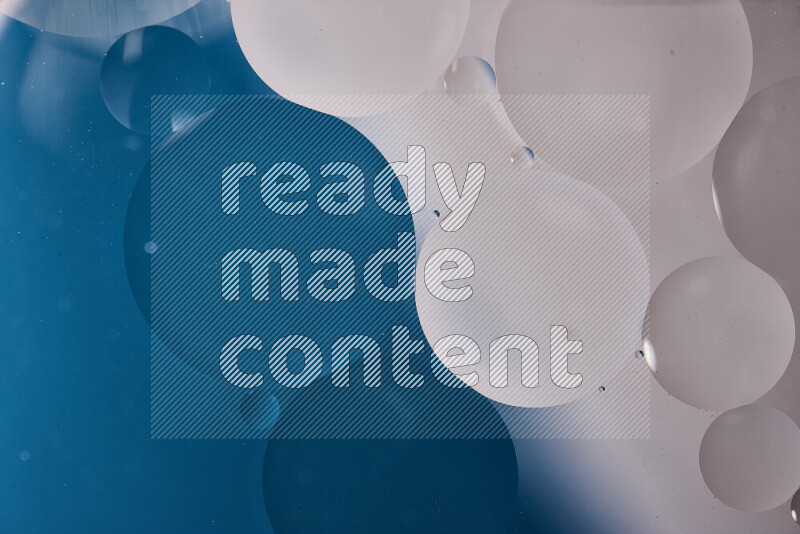 لقطات مقربة لفقاعات من الزيت على سطح الماء باللون الأبيض والأزرق