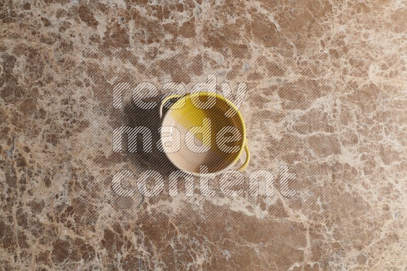 A multicolored pottery bowl on beige marble background