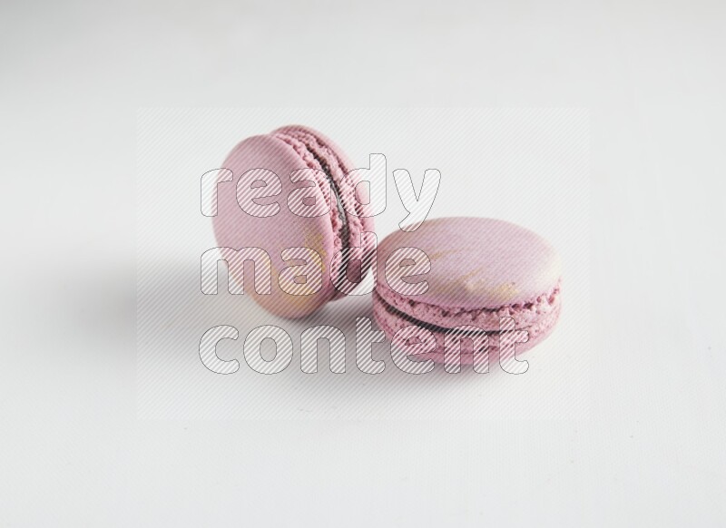 45º Shot of two Purple Strawberry macarons on white background