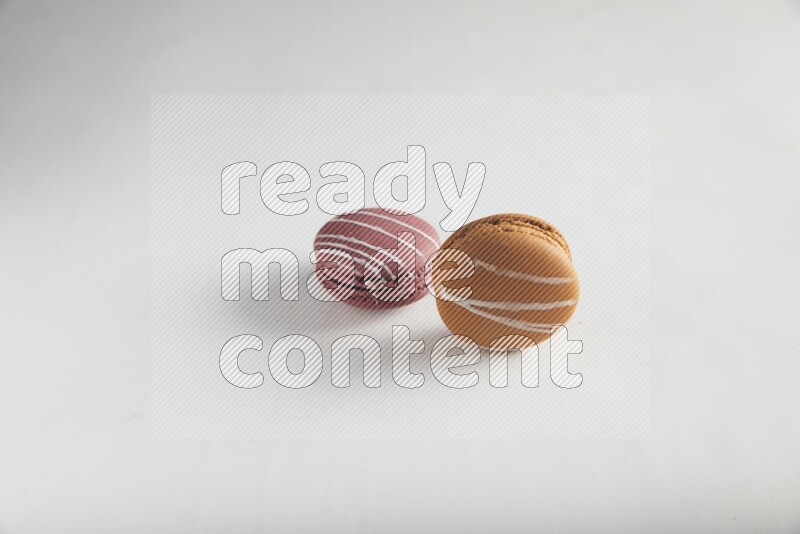 45º Shot of of two assorted Brown Irish Cream, and Red Poppy Flower macarons on white background