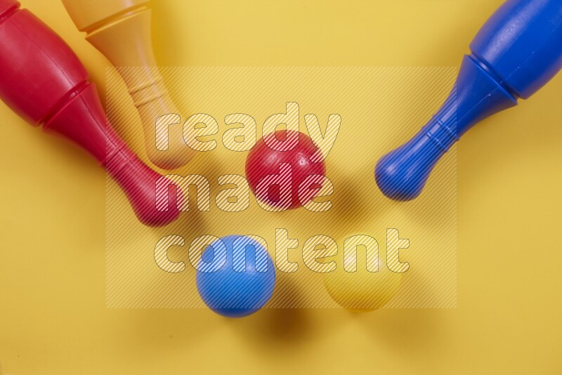 أوتاد البولينج البلاستيكية مع الكرات علي خلفيات ملونة مختلفة (ألعاب أطفال)