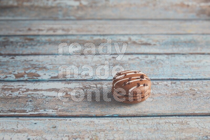 45º Shot of Brown white Chocolate Caramel macaron on light blue wooden background