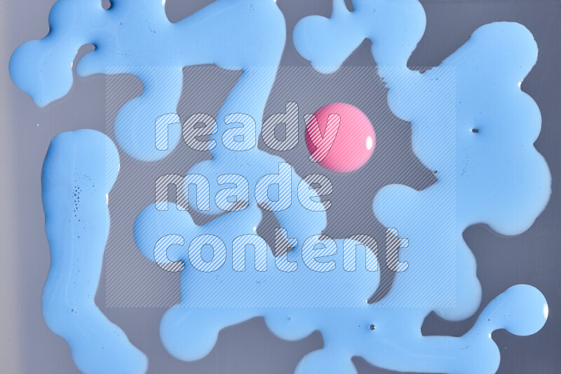 Close-ups of abstract pink and blue paint droplets on the surface