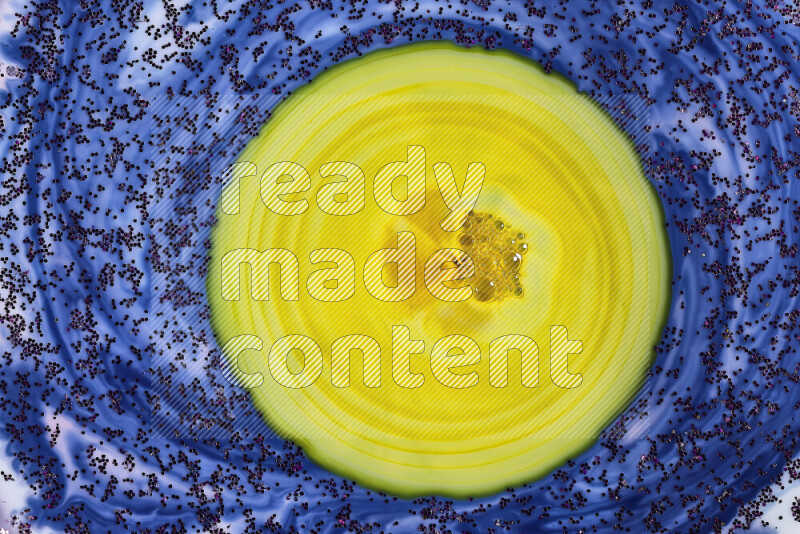 لقطة مقربة لبريق أرجواني متلألئ منتشر على خلفية من اللون الأزرق والأصفر في حركات دائرية