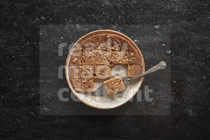 بسبوسة في أطباق مختلفه علي خلفية سوداء خشبية