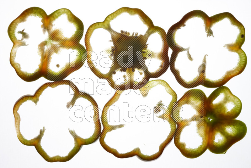 Colored bell pepper slices on illuminated white background