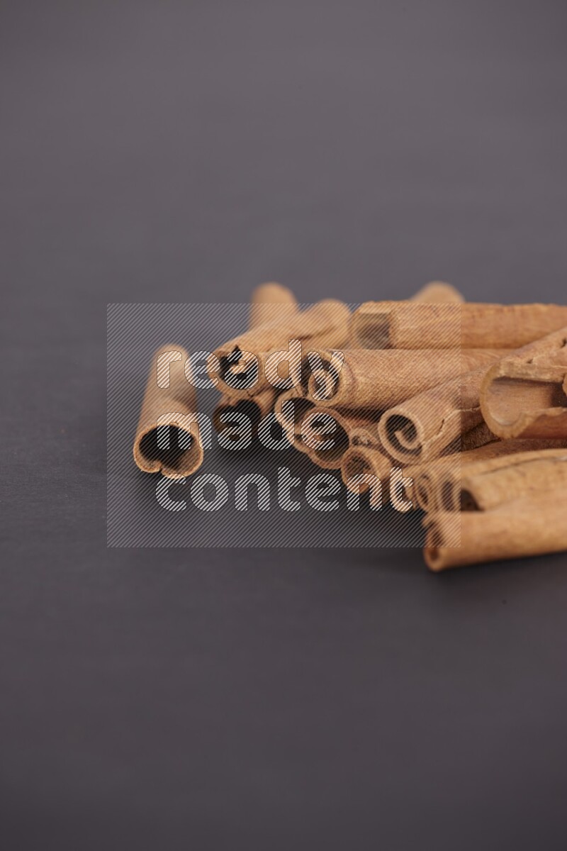 Cinnamon sticks stacked on black flooring