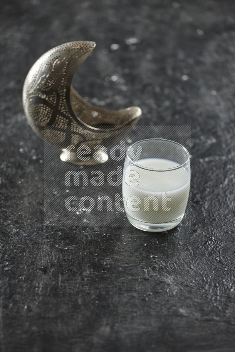 فانوس فضي مع مشروبات مختلفة وتمر ومكسرات وسبحة صلاة وقرآن على خلفية سوداء