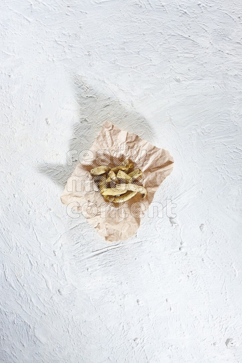 أصابع الكركم المجففة في قطعة من الورق على خلفية بيضاء