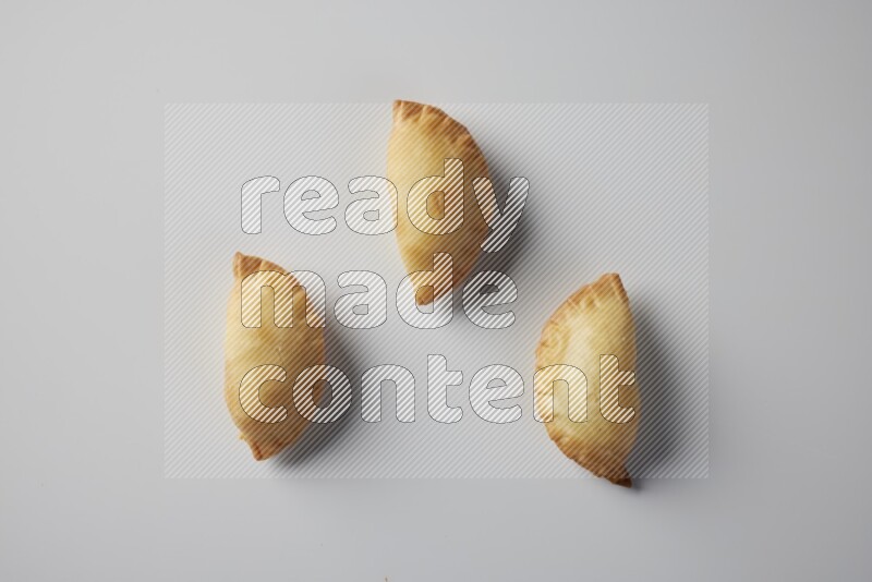 Three fried sambosa from a top angle on a white background