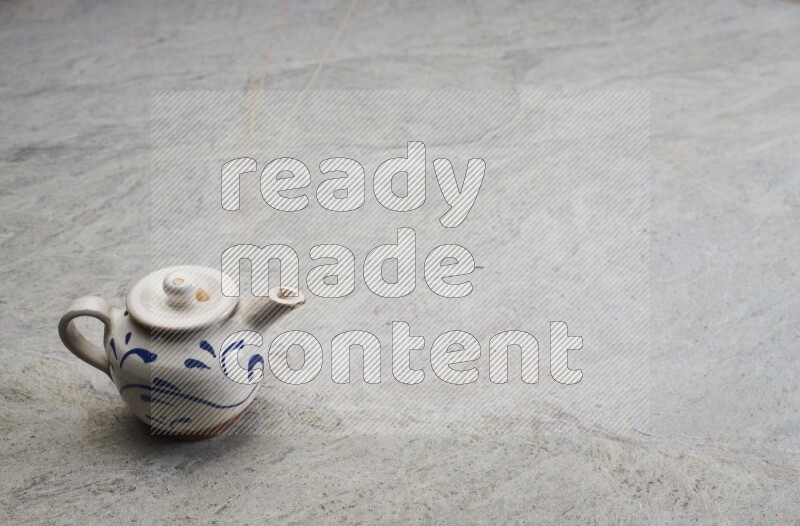 A pottery teapot on grey marble background