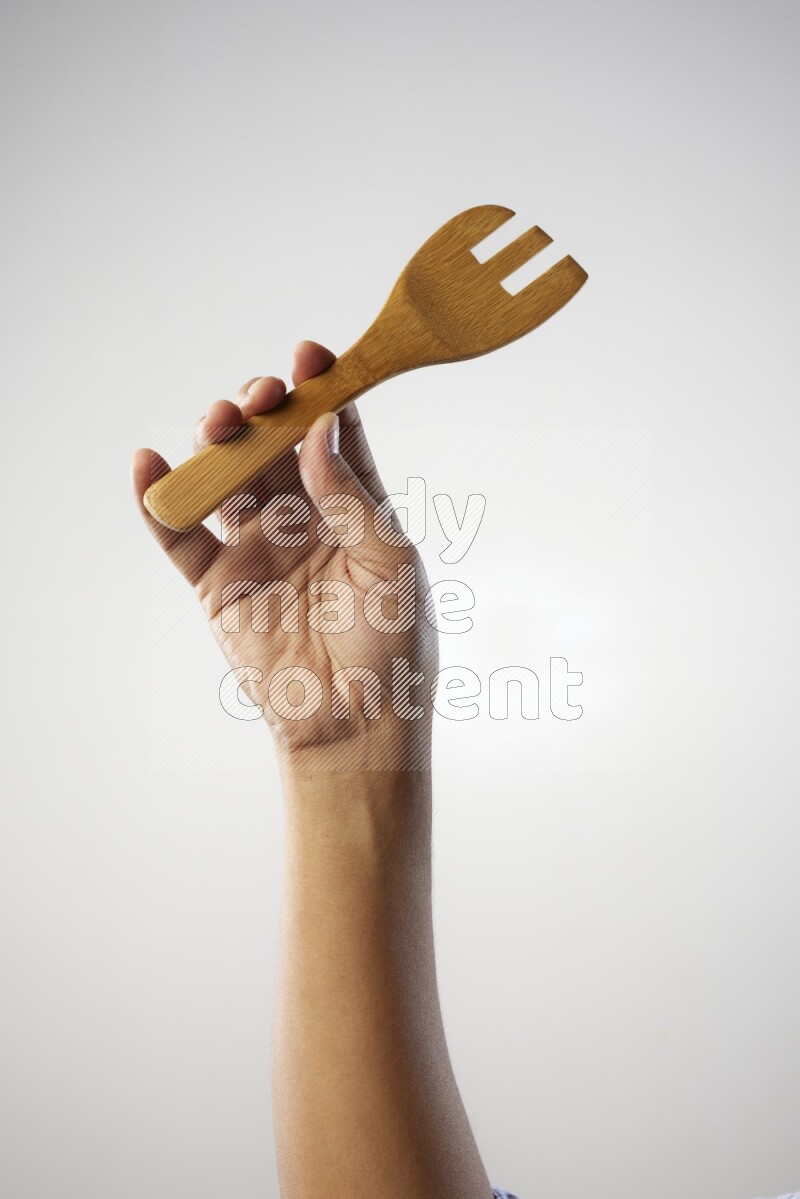 Male Hand Holding Wooden Fork on white  background
