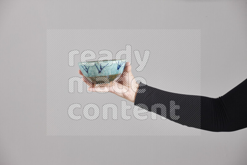 امرأة ترتدي عباءة سوداء تحمل أدوات فخارية مختلفة في أوضاع متعددة