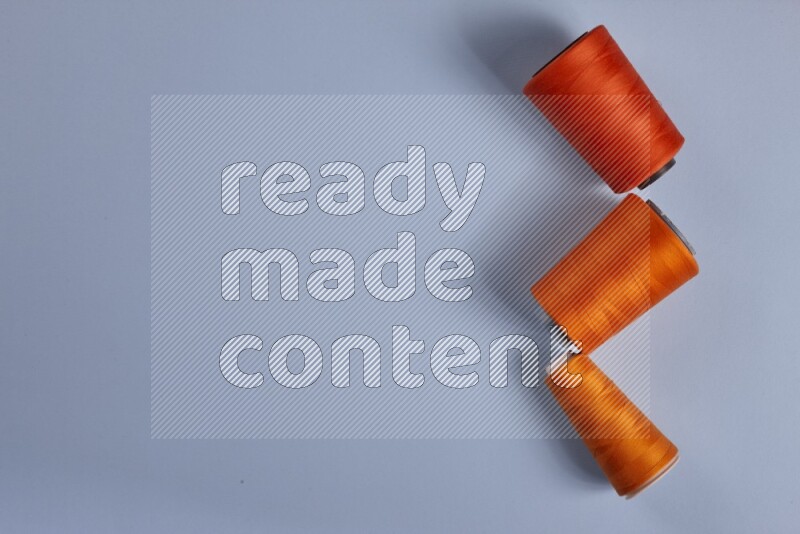 An orange collection of sewing and tailoring tools arranged on a blue background