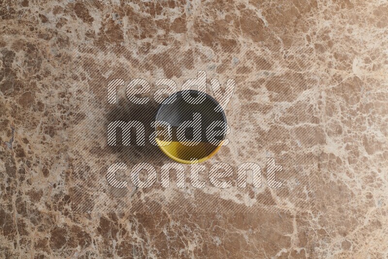 A multicolored pottery bowl on beige marble background