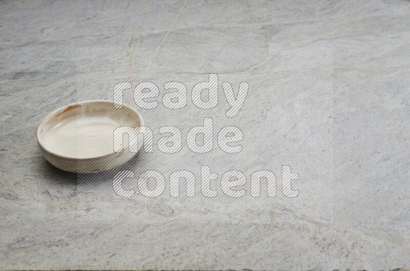 A multicolored pottery bowl on grey marble background