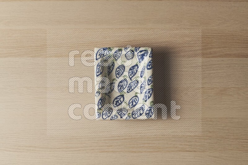A decorative pottery plate on light wooden background