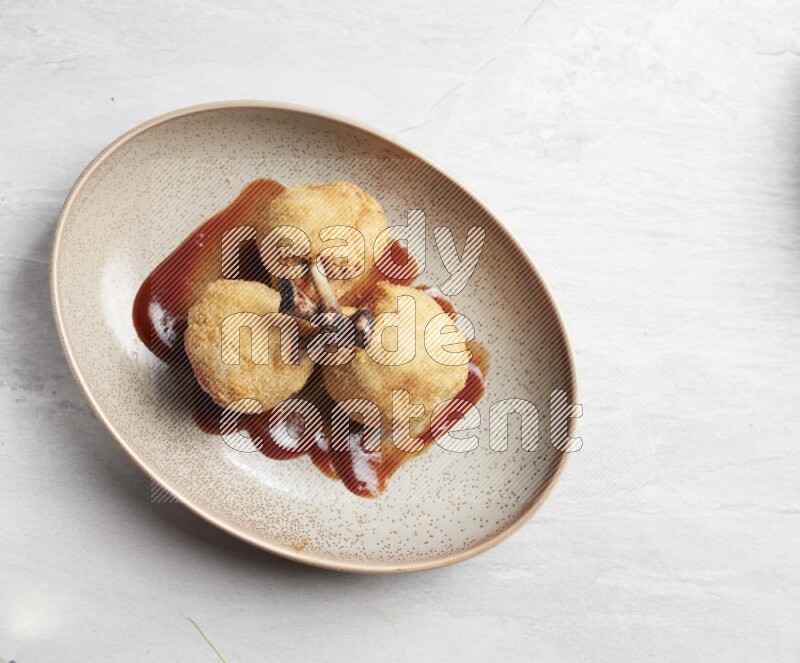 breaded drumstick on oval beige pottery plate on grey textured countertop