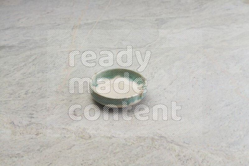 A multicolored pottery bowl on grey marble background