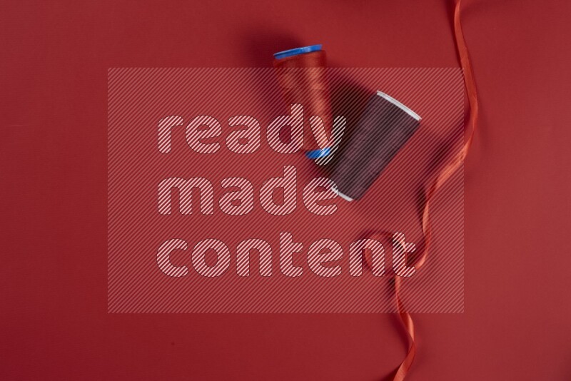 مجموعة من أدوات الخياطة والتفصيل حمراء اللون على خلفية حمراء