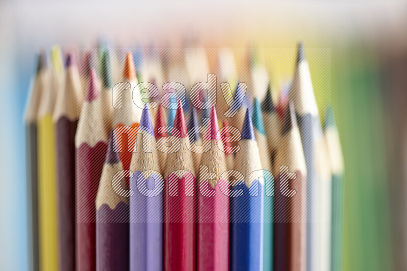 The image captures a close-up of sharpened colored pencils on multicolored background