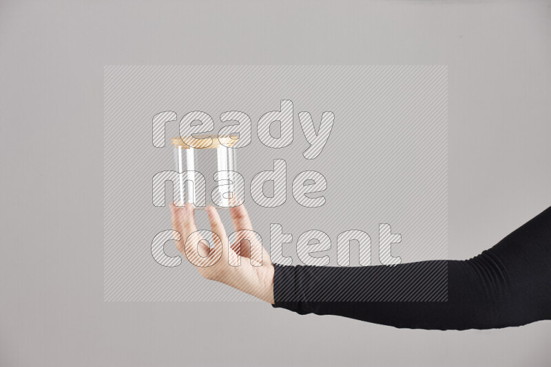 امرأة ترتدي عباءة سوداء تحمل أدوات زجاجية مختلفة في أوضاع متعددة