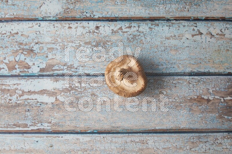 fresh shiitake Mushrooms topview on a light blue wooden textured background