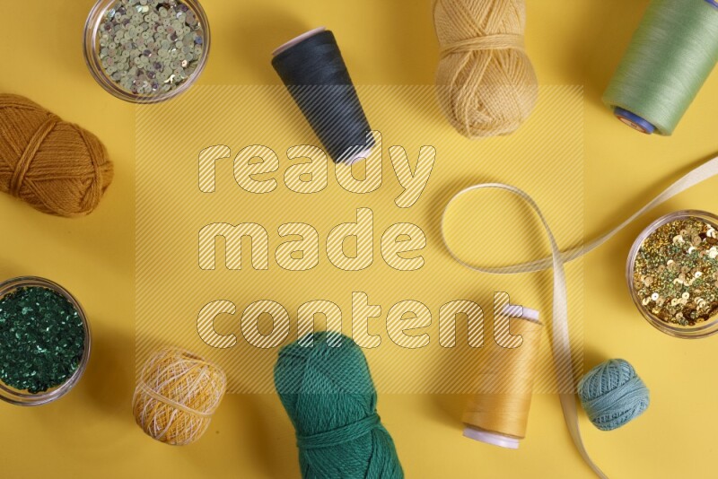 A green collection of sewing and tailoring tools arranged on a yellow background