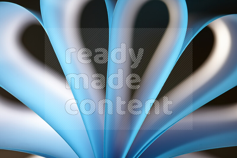 An abstract art piece displaying smooth curves in white and blue gradients created by colored light