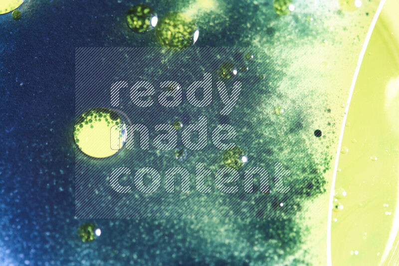 لقطات مقربة لقطرات ألوان مائية صفراء وزرقاء وخضراء على سطح الزيت على خلفية بيضاء